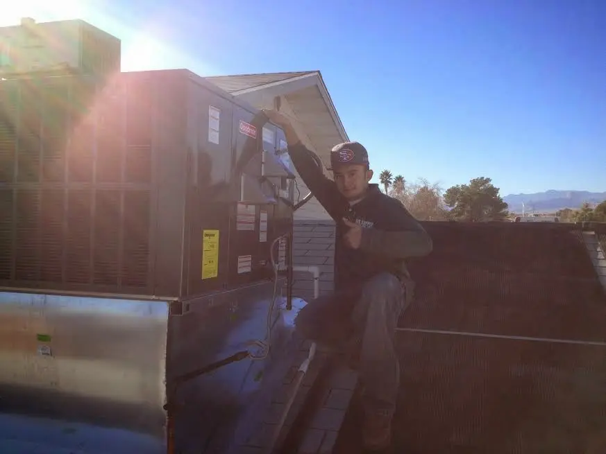 HVAC technician performing Heat Pump Repair on a rooftop unit in Berlin